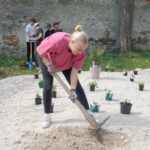 Schülerin arbeitet mit einer Hacke im Garten