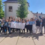 Gruppe von Lehrlingen hält ein Transparent mit der Aufschrift LBS Geras